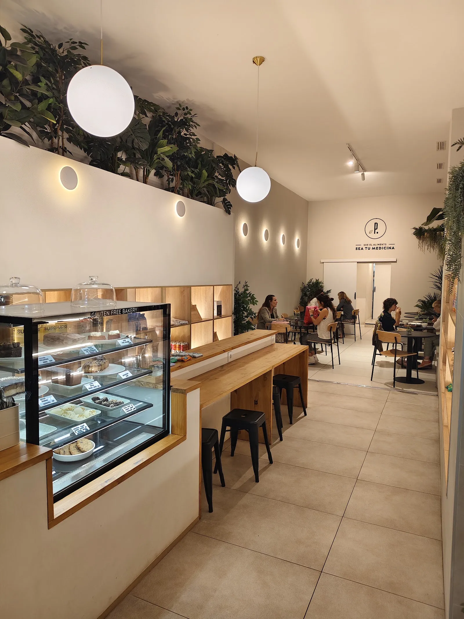 La sala, con la vitrina de pastelería y mesas al fondo