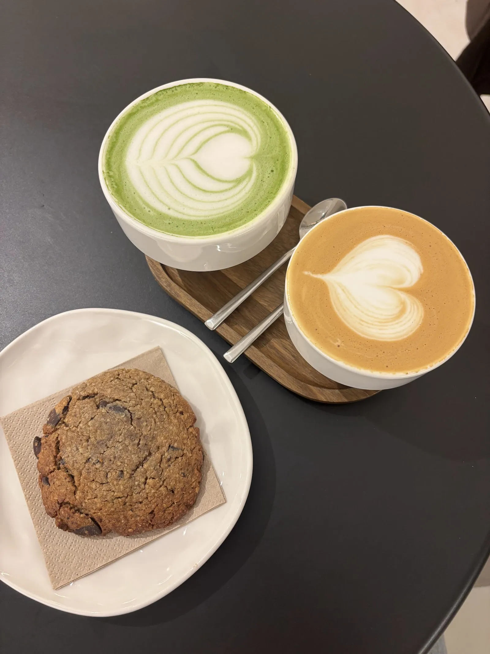 Un matcha latte, un café con leche y una cookie